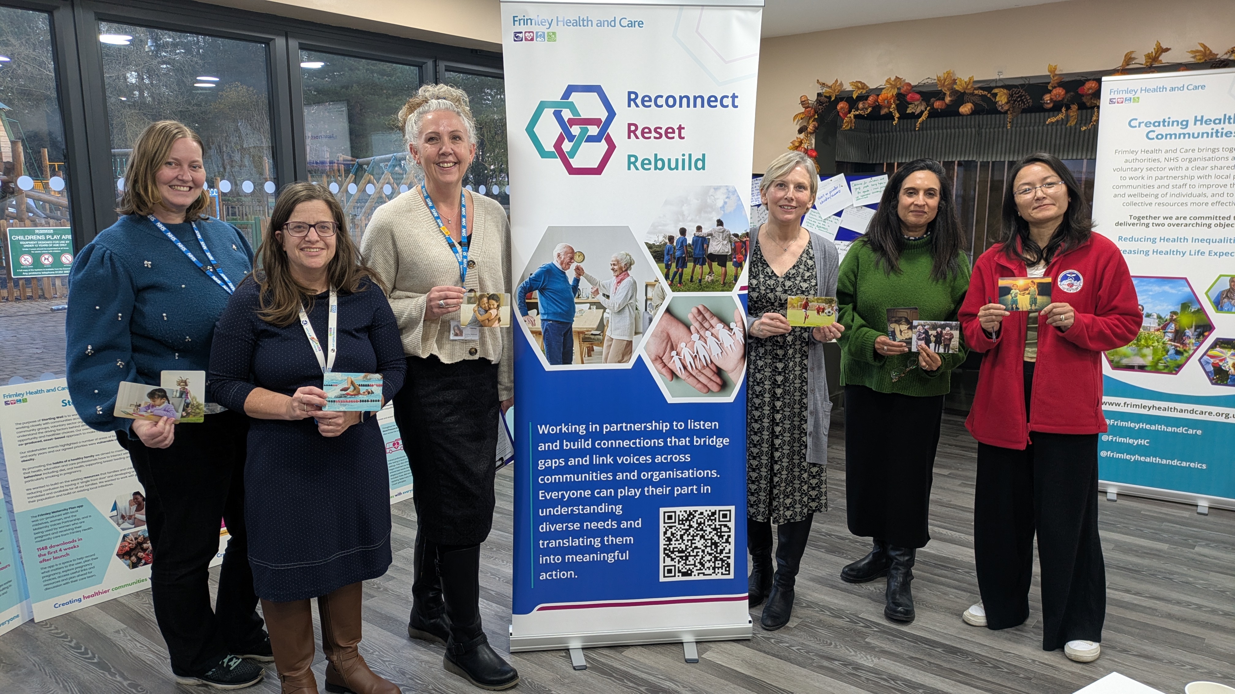 Group of people standing round RRR event pull up banner who have completed the RRR event 